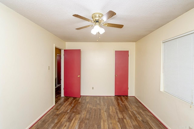 spare room with dark hardwood / wood-style floors, ceiling fan, and a textured ceiling