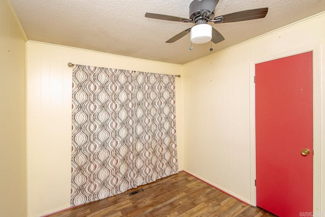 empty room with a textured ceiling, hardwood / wood-style flooring, and ceiling fan