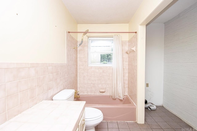 full bathroom featuring vanity, tile patterned flooring, toilet, shower / bathtub combination with curtain, and tile walls