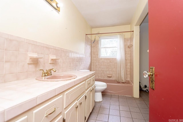 full bathroom featuring tile patterned floors, vanity, shower / tub combo with curtain, tile walls, and toilet