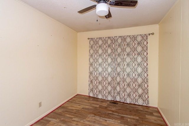 unfurnished room with ceiling fan, dark wood-type flooring, and a textured ceiling