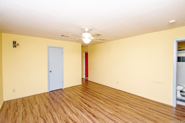 unfurnished room featuring light wood-type flooring and a textured ceiling