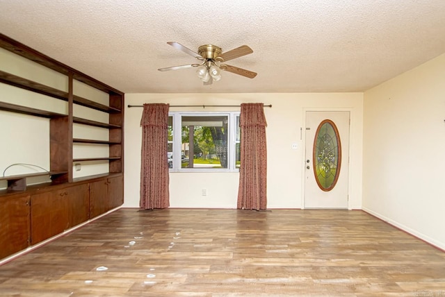 entrance foyer featuring ceiling fan, light hardwood / wood-style floors, and a textured ceiling