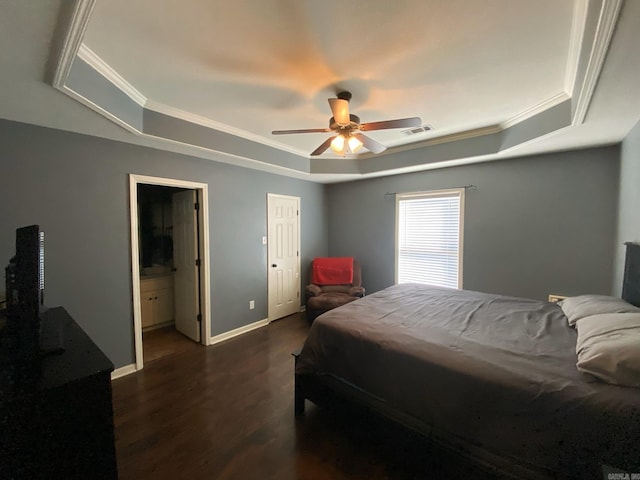 bedroom featuring connected bathroom, a tray ceiling, ceiling fan, and dark hardwood / wood-style floors