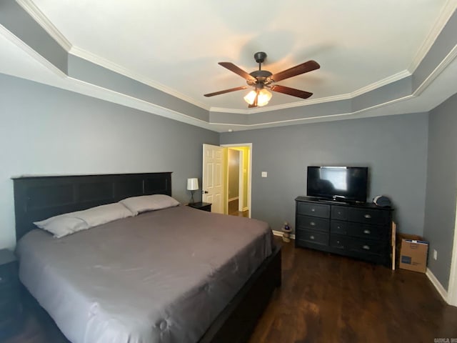 bedroom with ceiling fan, dark wood-type flooring, crown molding, and a tray ceiling