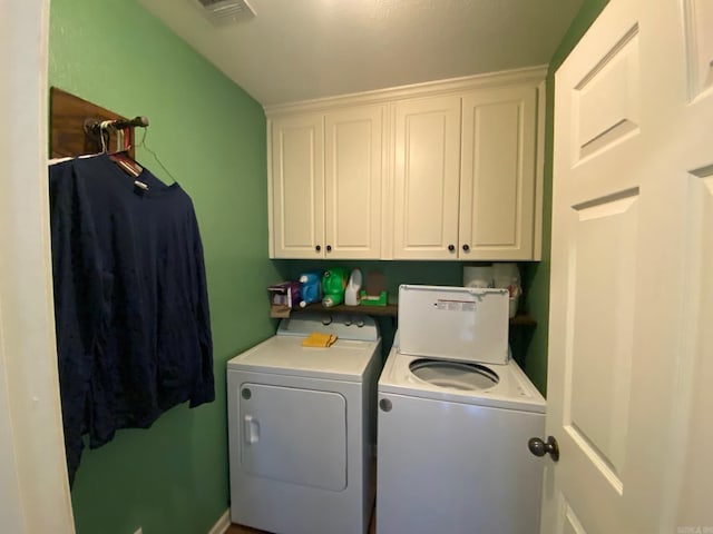 clothes washing area featuring cabinets and separate washer and dryer