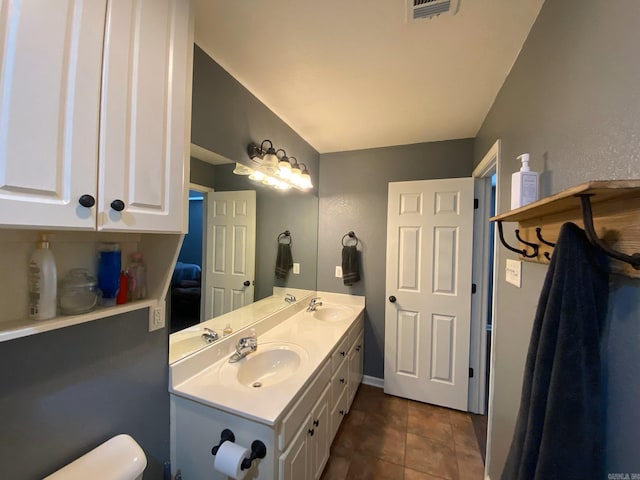 bathroom featuring tile patterned flooring, vanity, and toilet