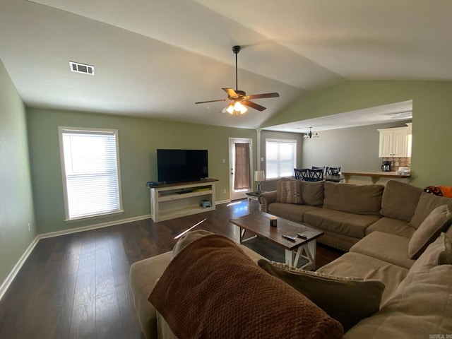 living area with visible vents, a ceiling fan, vaulted ceiling, wood finished floors, and baseboards