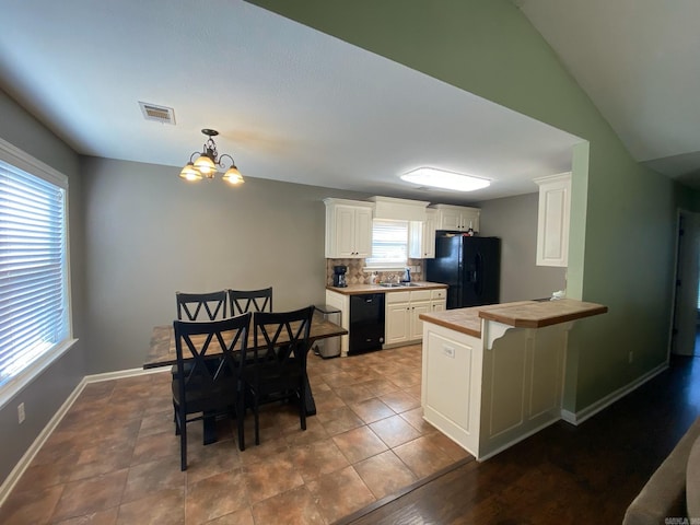 kitchen featuring kitchen peninsula, tile countertops, white cabinets, and black appliances