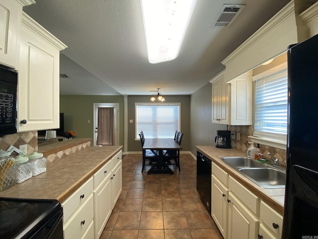 kitchen featuring tile countertops, backsplash, and black appliances