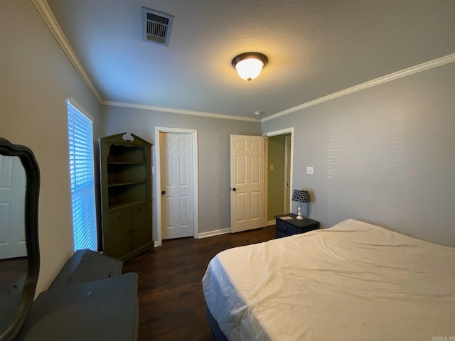 bedroom featuring a textured ceiling, dark hardwood / wood-style floors, and crown molding