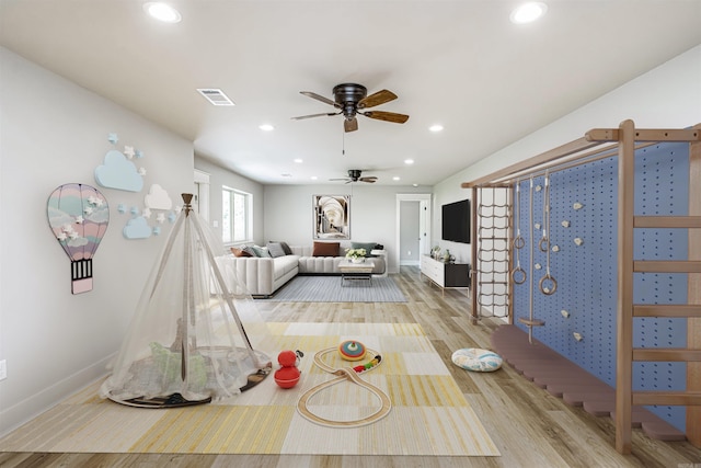 playroom with light wood-type flooring and ceiling fan