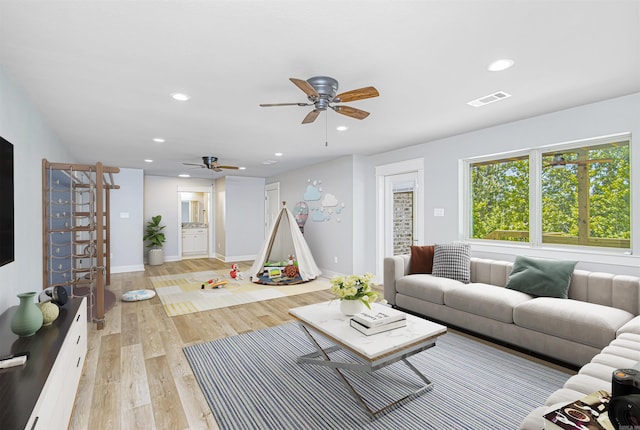 living room featuring ceiling fan and light wood-type flooring