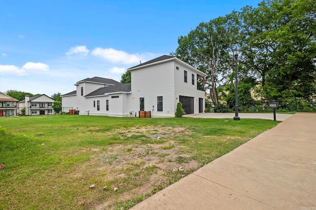 view of side of property featuring a lawn and a garage