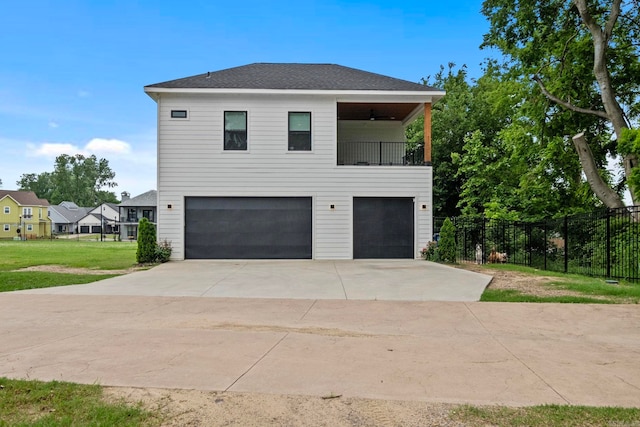 view of side of home featuring a garage, a balcony, and a yard