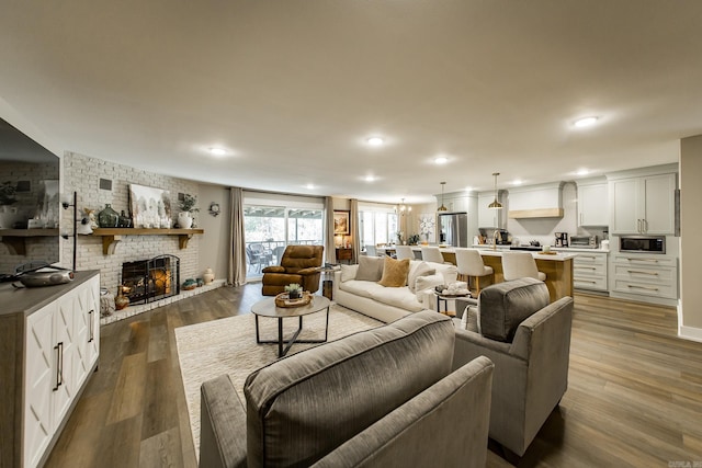 living room with hardwood / wood-style flooring and a brick fireplace