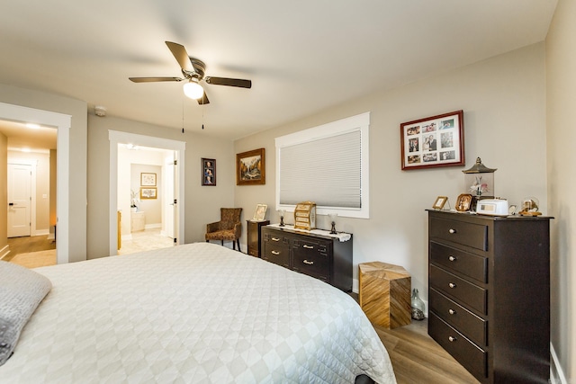 bedroom featuring ceiling fan, light wood-type flooring, and connected bathroom