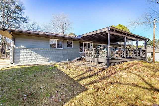 rear view of property featuring a lawn and a wooden deck