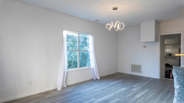 unfurnished dining area featuring hardwood / wood-style floors and a notable chandelier