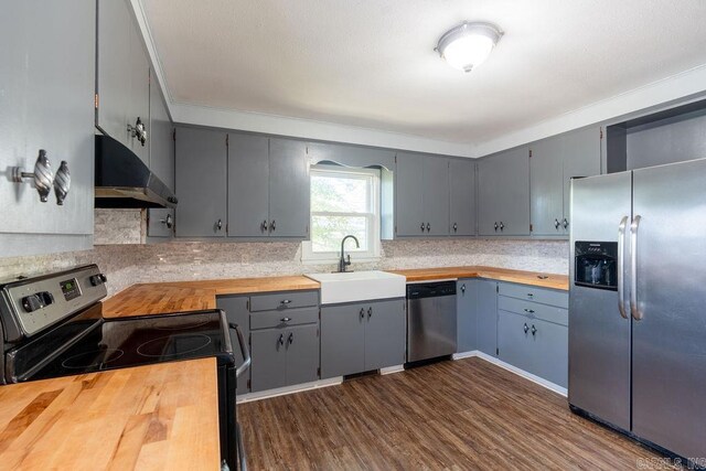 kitchen featuring gray cabinetry, a sink, extractor fan, appliances with stainless steel finishes, and wood counters