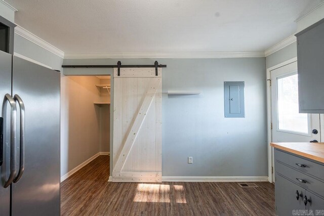 kitchen featuring electric panel, wood finished floors, a barn door, and ornamental molding