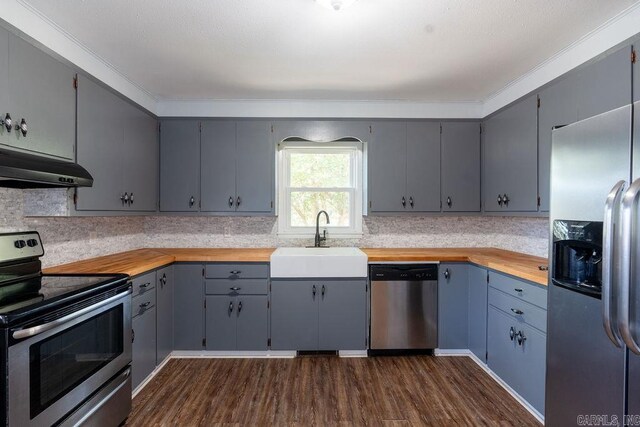 kitchen with a sink, appliances with stainless steel finishes, gray cabinetry, and under cabinet range hood