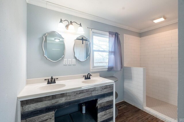 full bath with a sink, wood finished floors, and crown molding