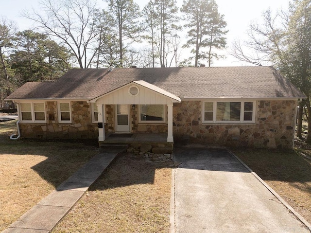 single story home featuring stone siding, driveway, and a shingled roof