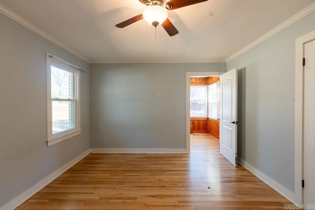 unfurnished room featuring ceiling fan, baseboards, ornamental molding, and light wood finished floors