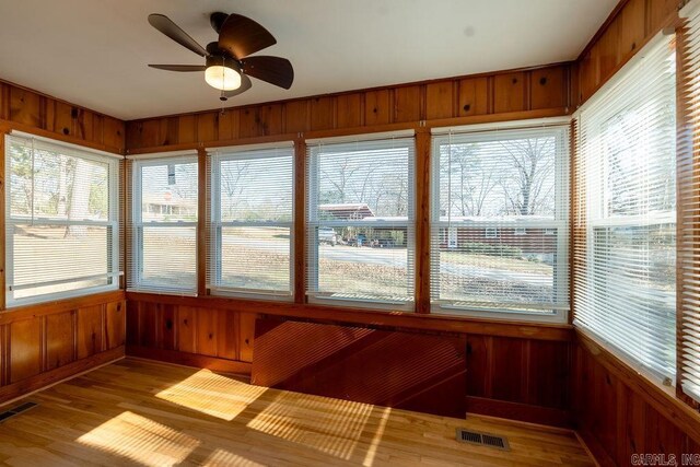 unfurnished sunroom featuring visible vents and ceiling fan