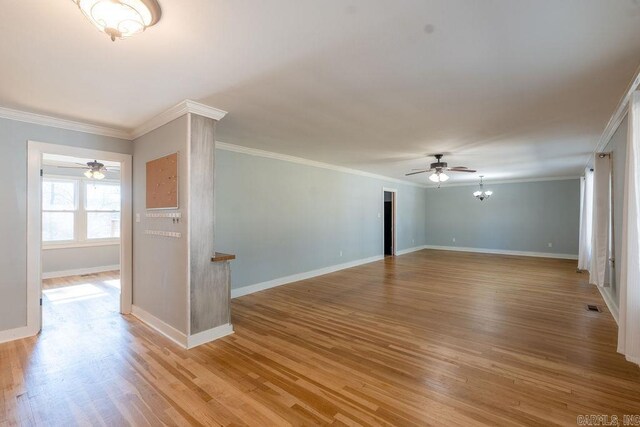 spare room featuring a ceiling fan, baseboards, visible vents, crown molding, and light wood-type flooring