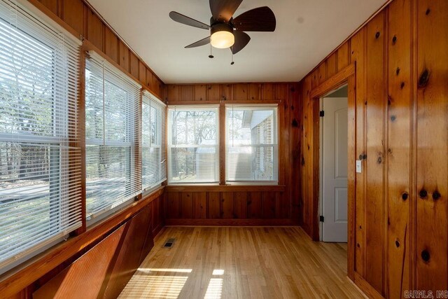 unfurnished sunroom featuring visible vents and a ceiling fan