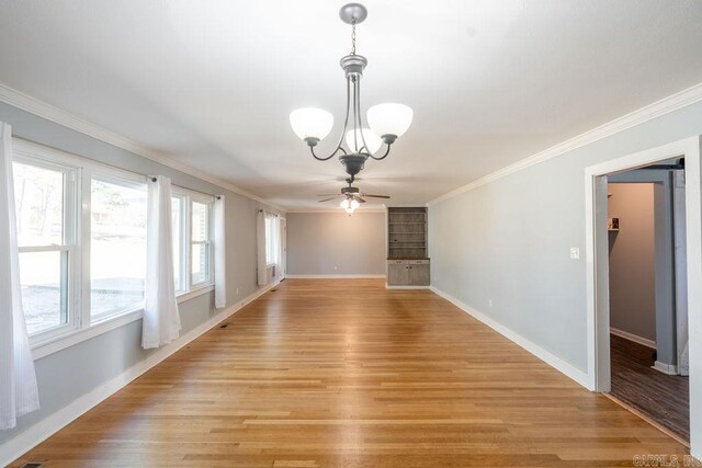 interior space featuring baseboards, light wood-style floors, ornamental molding, and ceiling fan with notable chandelier