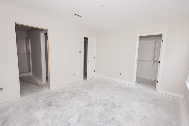 unfurnished bedroom featuring a walk in closet