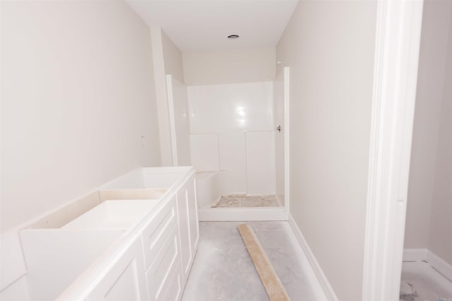 bathroom featuring a shower and vanity