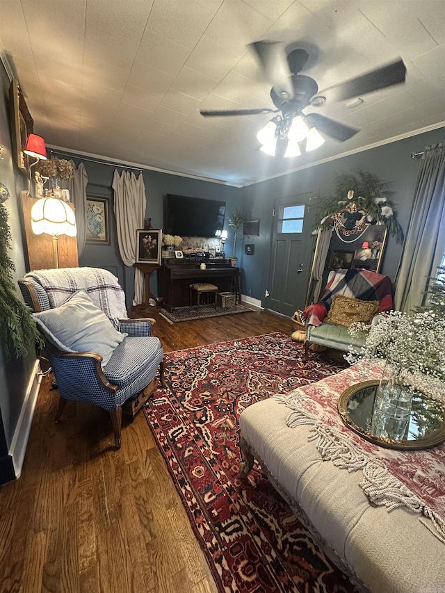 living room featuring ceiling fan, dark hardwood / wood-style flooring, and crown molding