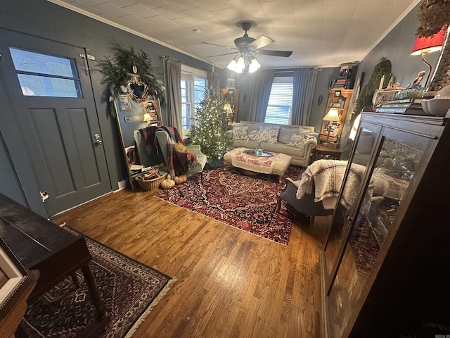 living room featuring ceiling fan, ornamental molding, and hardwood / wood-style flooring