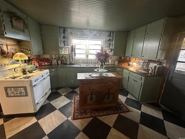 kitchen featuring white range oven, green cabinets, and sink