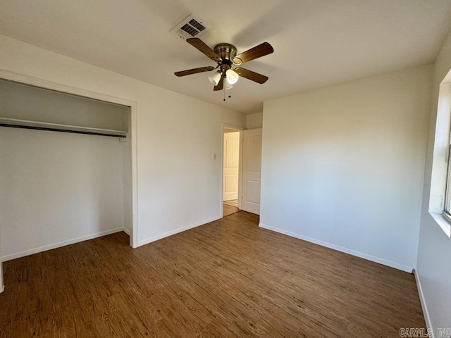 unfurnished bedroom with a closet, ceiling fan, and dark wood-type flooring