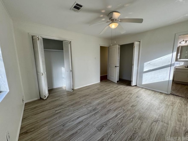 unfurnished bedroom with connected bathroom, ceiling fan, and light hardwood / wood-style floors