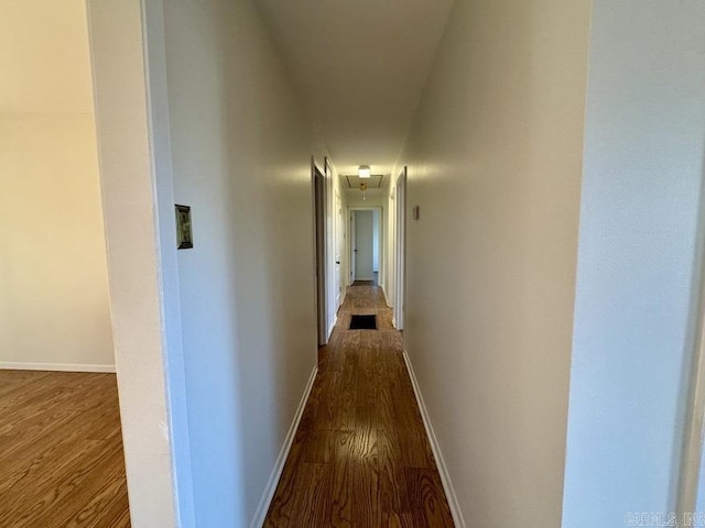 corridor with hardwood / wood-style flooring