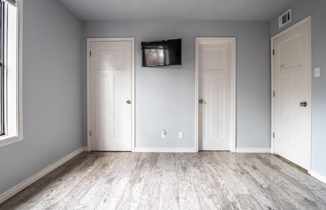 unfurnished bedroom with light wood-type flooring