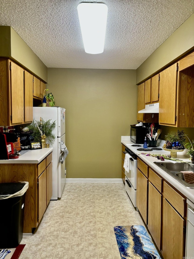 kitchen with a textured ceiling, sink, and white appliances