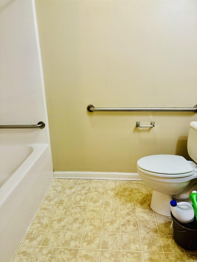 bathroom with a bathing tub, tile patterned flooring, and toilet