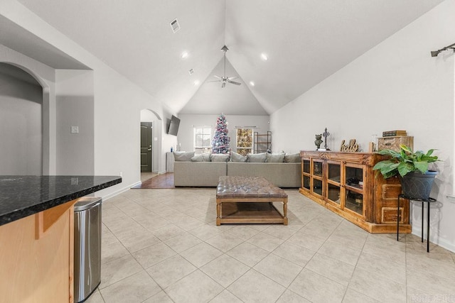 living room featuring ceiling fan, light tile patterned floors, and lofted ceiling