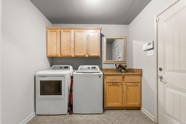 laundry area featuring cabinets, independent washer and dryer, a textured ceiling, and light tile patterned floors