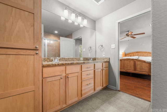 bathroom with tile patterned floors, ceiling fan, an enclosed shower, and vanity