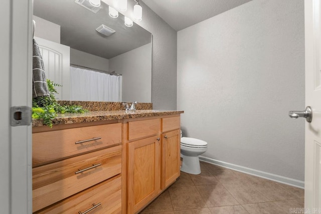 bathroom with tile patterned flooring, vanity, and toilet