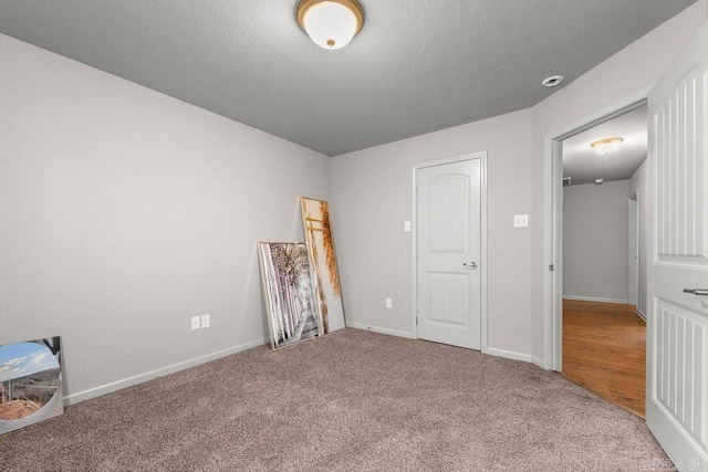 unfurnished bedroom featuring carpet flooring and a textured ceiling