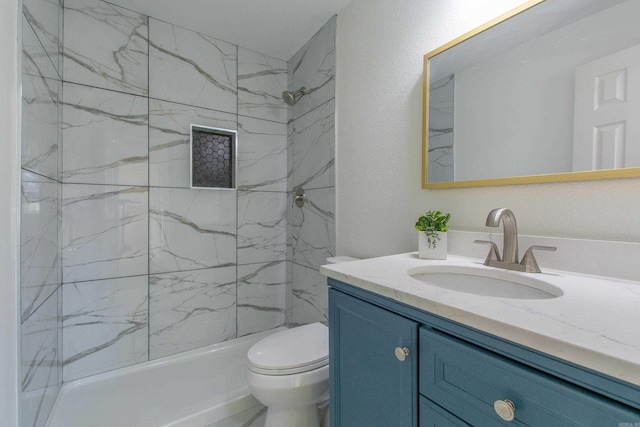 bathroom with vanity, toilet, and a tile shower